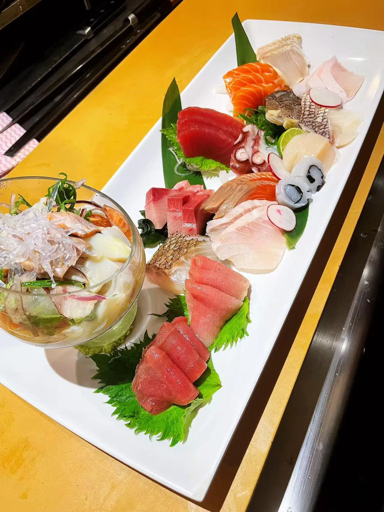 Assorted Sashimi Platter includes a selection of fresh raw fish slices, such as tuna, salmon, octopus, and scallop, along with a bowl of sashimi salad at Kokoro Sushi, a Japanese restaurant in CA