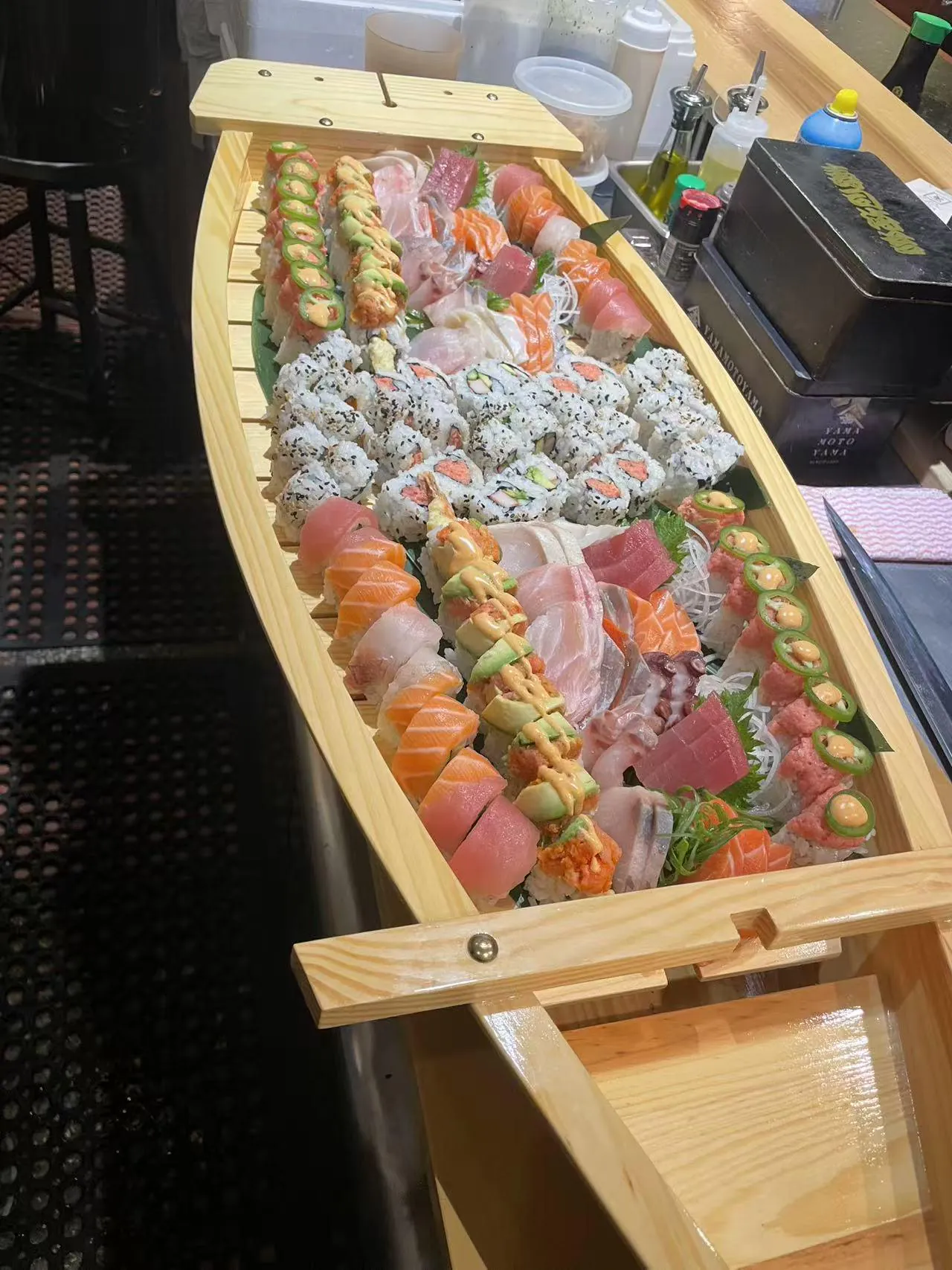 Sushi Boat Platter offers a large - scale assortment of sushi and sashimi, with various types of rolls and raw fish slices at Kokoro Sushi, a Japanese restaurant in CA